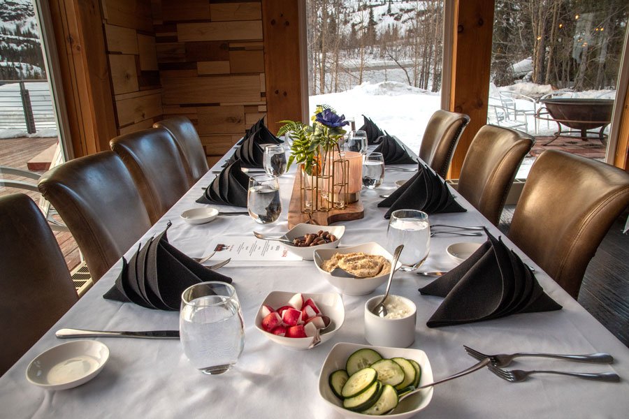 A restaurant table set with appetizers at the Tsaina Lodge